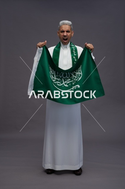 رجل سعودي يمسك العلم ويصرخ في الاستوديو