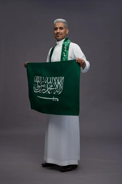 رجل سعودي يحمل العلم الوطني في الاستوديو