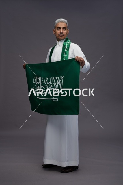 Saudi Man in Traditional Thobe Holding National Flag