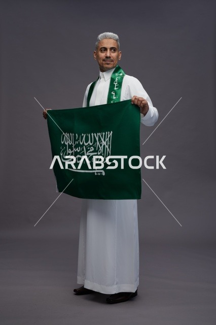 Saudi Man Holding Saudi Arabia Flag in Studio