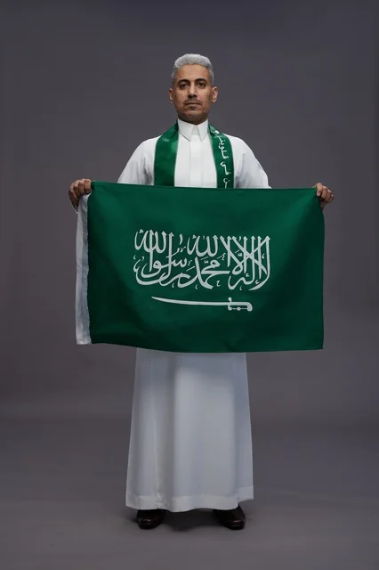 رجل سعودي يمسك بالعلم الوطني السعودي