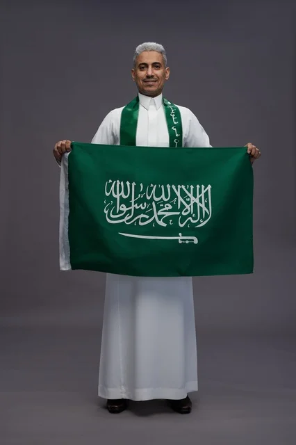 رجل سعودي يحمل علم المملكة العربية السعودية