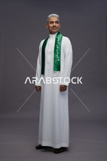 رجل سعودي بالثوب التقليدي ووشاح اليوم الوطني