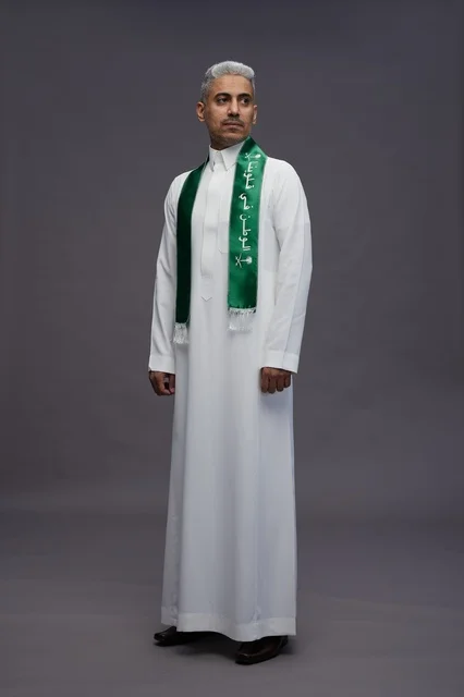 رجل سعودي بالثوب الأبيض ووشاح اليوم الوطني