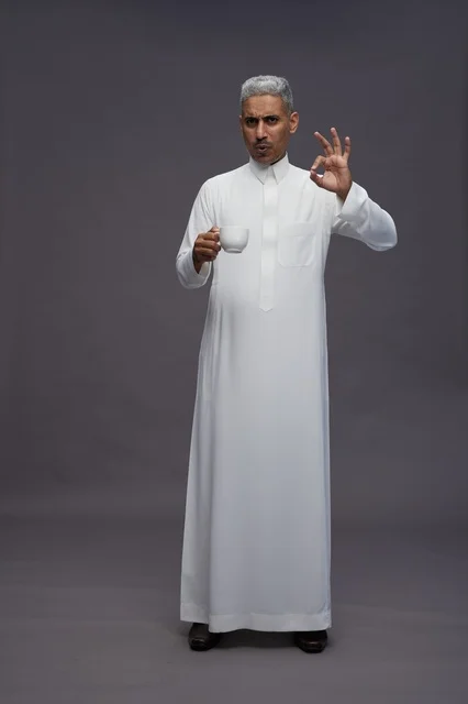 رجل سعودي بالثوب الأبيض يحمل فنجان قهوة