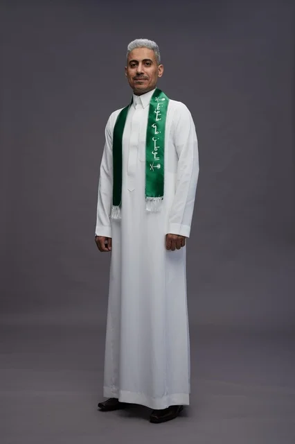 رجل سعودي بالثوب ووشاح اليوم الوطني