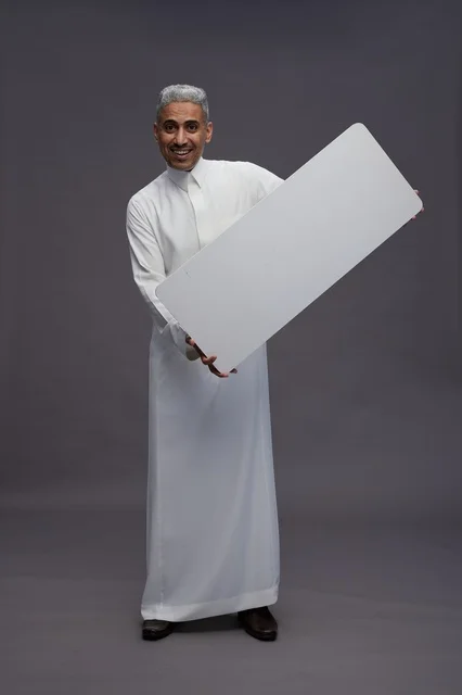 رجل سعودي يحمل لوحة بيضاء فارغة في الاستوديو
