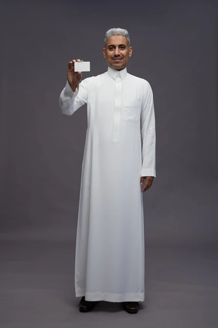 رجل سعودي يحمل بطاقة عمل فارغة في الاستوديو