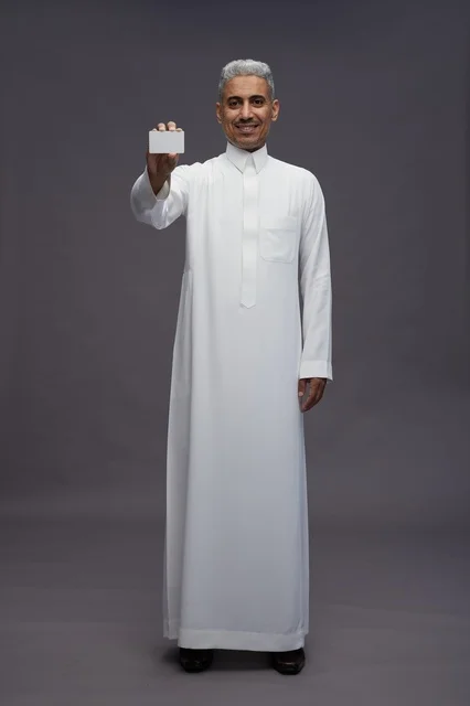 رجل سعودي يحمل بطاقة بيضاء فارغة في الاستوديو