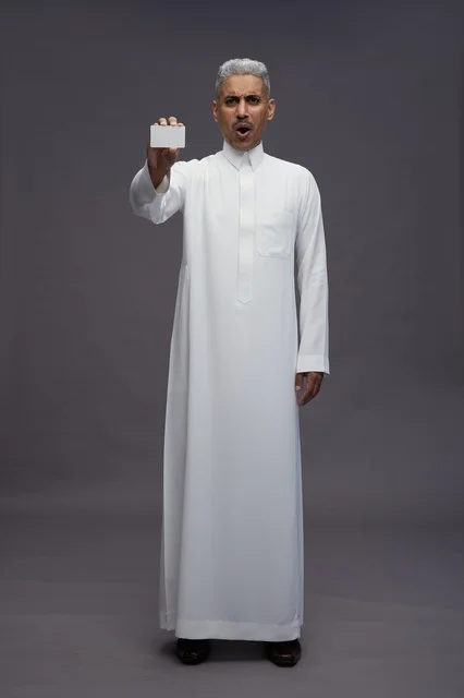 رجل سعودي مندهش يحمل بطاقة عمل بيضاء فارغة