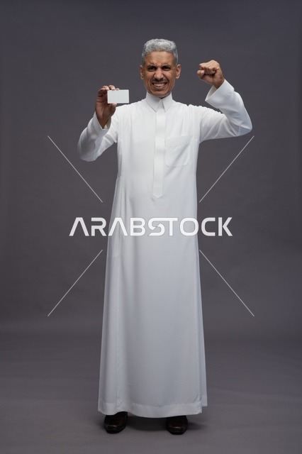 رجل سعودي يحمل بطاقة عمل فارغة بحماس