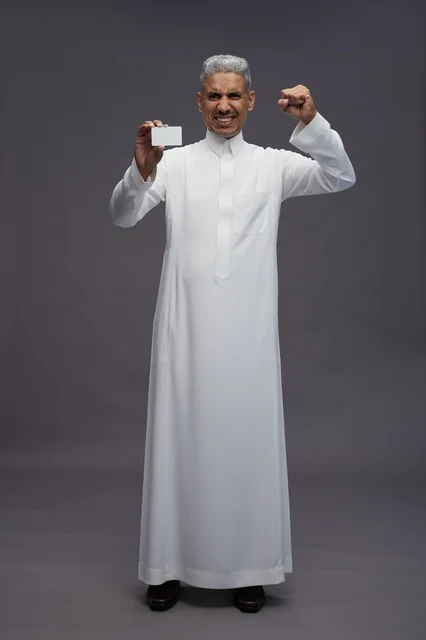 رجل سعودي يحمل بطاقة عمل فارغة بحماس