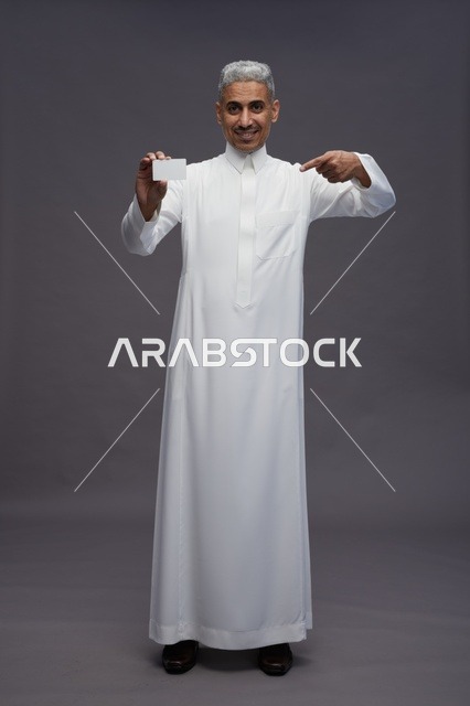 رجل سعودي بالثوب الأبيض يمسك بطاقة فارغة