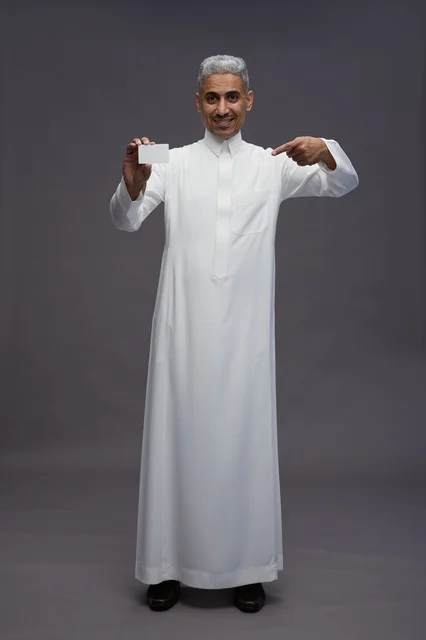 رجل سعودي بالثوب الأبيض يمسك بطاقة فارغة