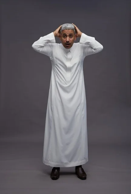 رجل سعودي مصدوم يرتدي الثوب الأبيض بخلفية رمادية