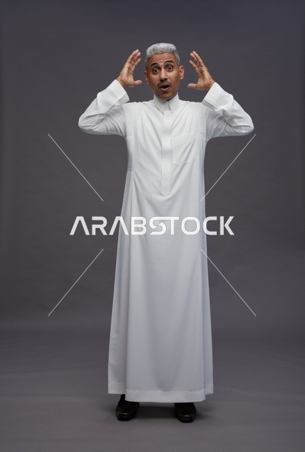 رجل سعودي مصدوم بالثوب الأبيض بخلفية رمادية