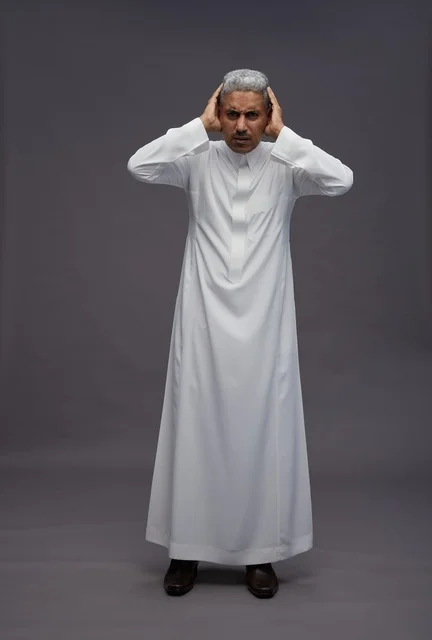 Saudi Man in Thobe Covering Ears on Grey Background