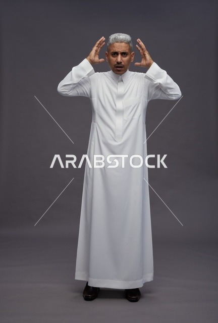 رجل سعودي مصدوم بالثوب الأبيض بخلفية رمادية