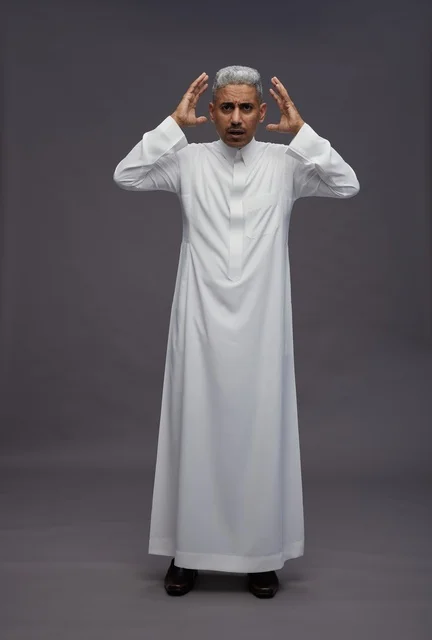 رجل سعودي مصدوم بالثوب الأبيض بخلفية رمادية