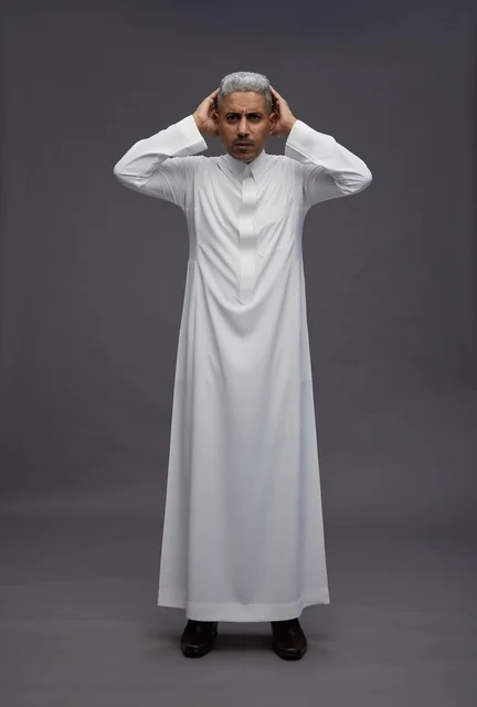 رجل سعودي بالثوب الأبيض بتعبيرات مرتبكة في الاستوديو