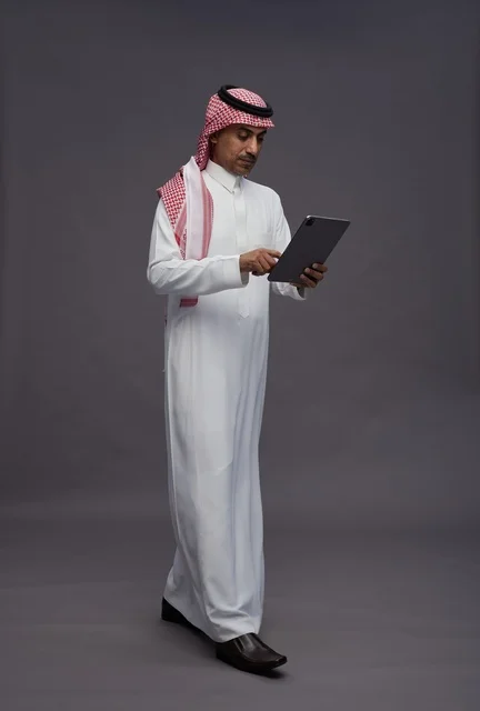 Saudi Man in Traditional Thobe Using Tablet Studio