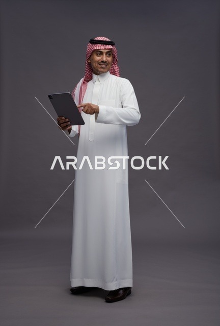 Saudi Man Holding Digital Tablet on Grey Background