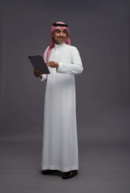 Saudi Man Holding Digital Tablet on Grey Background
