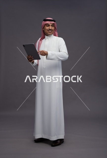 Saudi Man with Digital Tablet on Grey Background