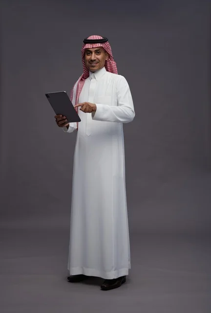 Saudi Man in Traditional Thobe Holding Digital Tablet
