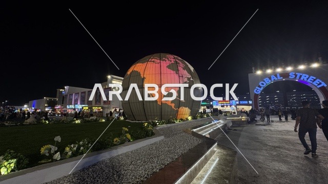 The globe sculpture in the Global Street of Winter Wonderland Jeddah at night.