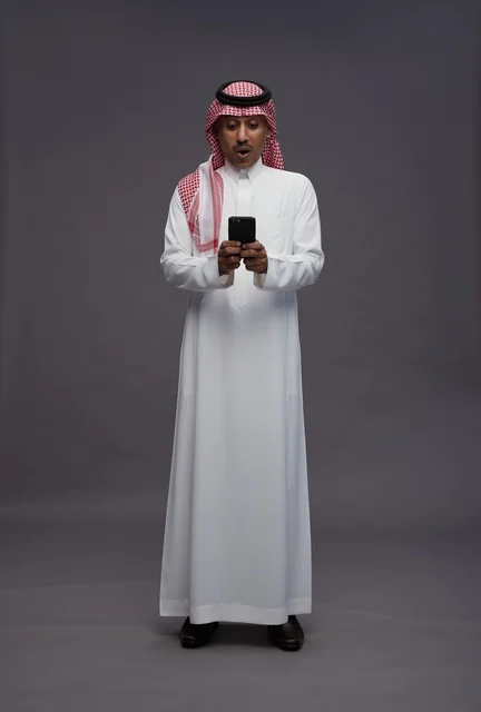 رجل سعودي مصدوم يستخدم الهاتف الذكي في الاستوديو