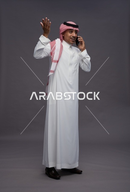 رجل سعودي بالزي التقليدي يتحدث عبر الهاتف