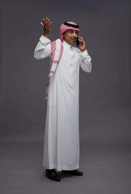 رجل سعودي بالزي التقليدي يتحدث عبر الهاتف