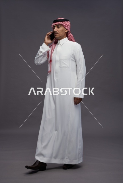 رجل سعودي بالزي التقليدي يجري مكالمة هاتفية