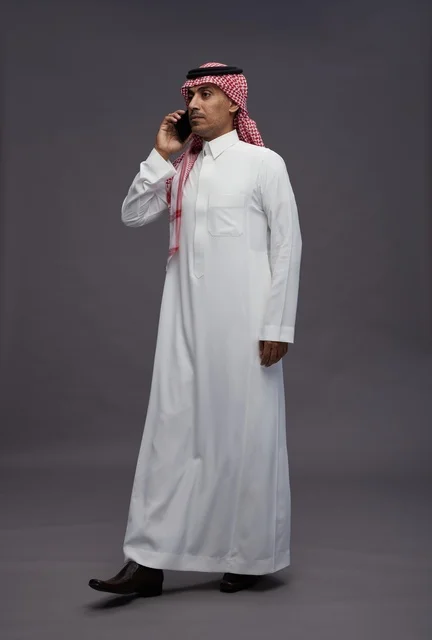 رجل سعودي بالزي التقليدي يجري مكالمة هاتفية