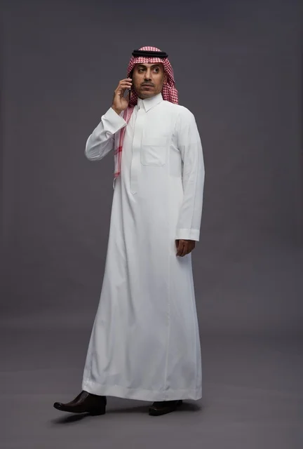 Saudi Man in Traditional Thobe Talking on Mobile Phone