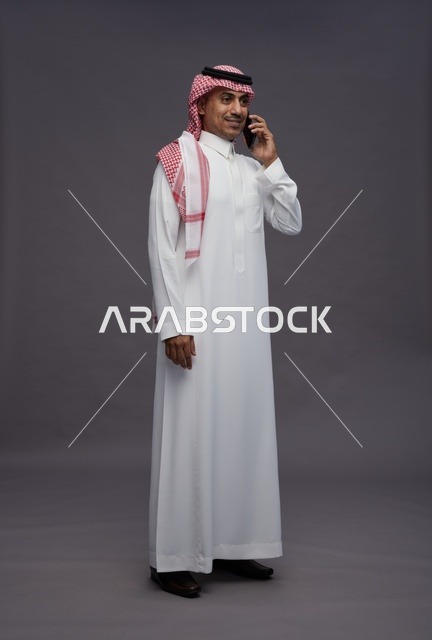 Saudi Man Talking on Smartphone in Traditional Thobe