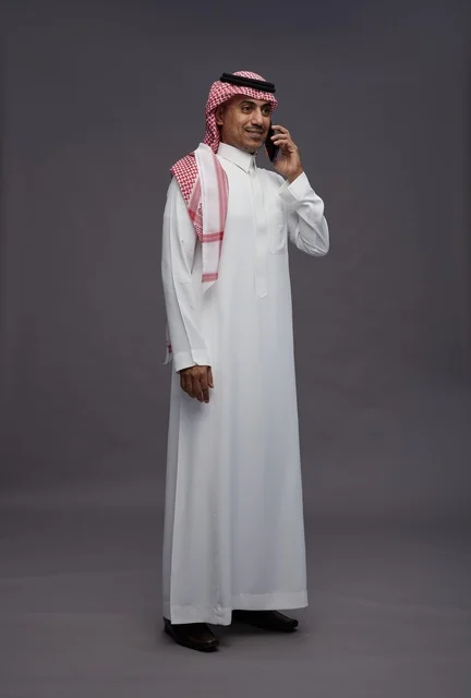 رجل سعودي يتحدث بالهاتف الجوال بالزي التقليدي