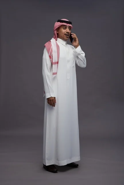 رجل سعودي بالثوب يتحدث بالجوال في الاستوديو