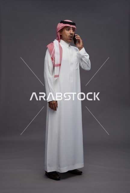 رجل سعودي مندهش يتحدث بالجوال في الاستوديو