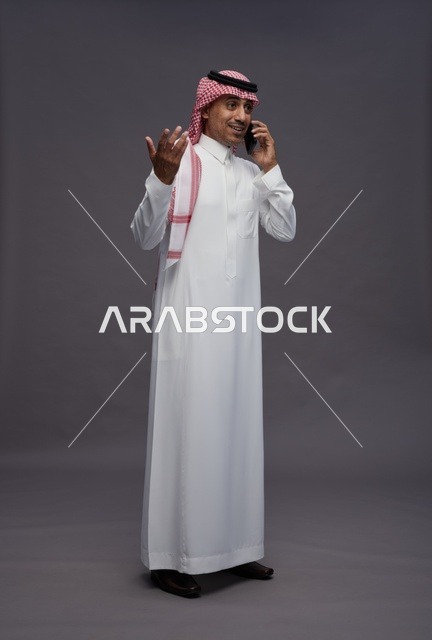 Saudi Man in Traditional Thobe Talking on Mobile Phone