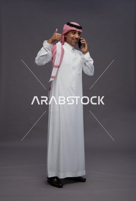 Saudi Man with Smartphone Giving Thumbs Up Gesture