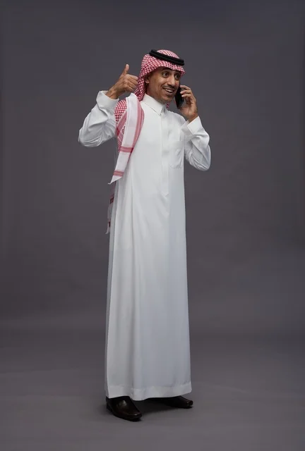 Saudi Man with Smartphone Giving Thumbs Up Gesture