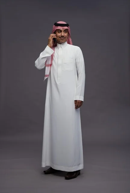 رجل سعودي بالثوب يتحدث بالهاتف الجوال في الاستوديو