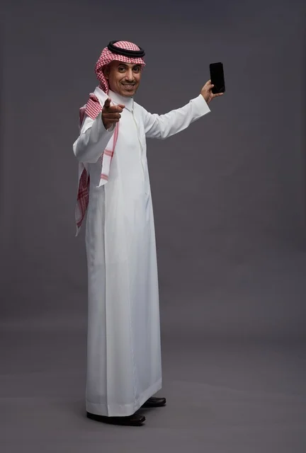 Saudi Man Holding Smartphone on Grey Background