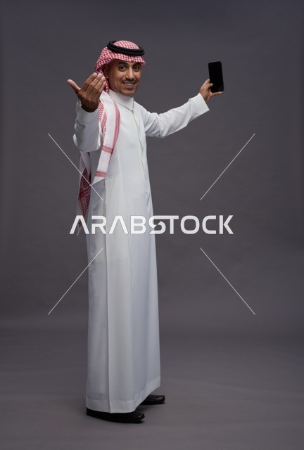 Saudi Man with Smartphone Making Welcoming Gesture