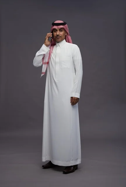 رجل سعودي بالثوب التقليدي يتحدث عبر الهاتف