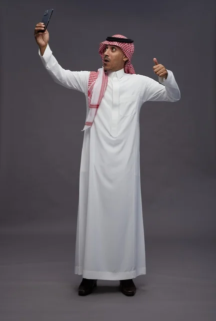 Saudi Man in Thobe Taking Selfie with Thumbs Up