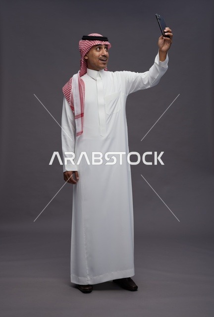 Saudi Man in Traditional Thobe Taking Smartphone Selfie