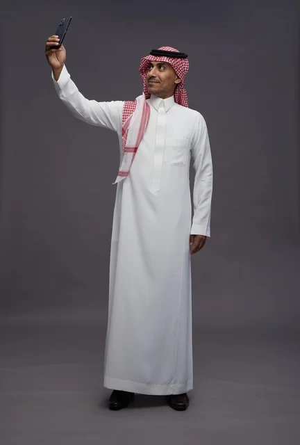 Saudi Man in Traditional Thobe Taking Smartphone Selfie